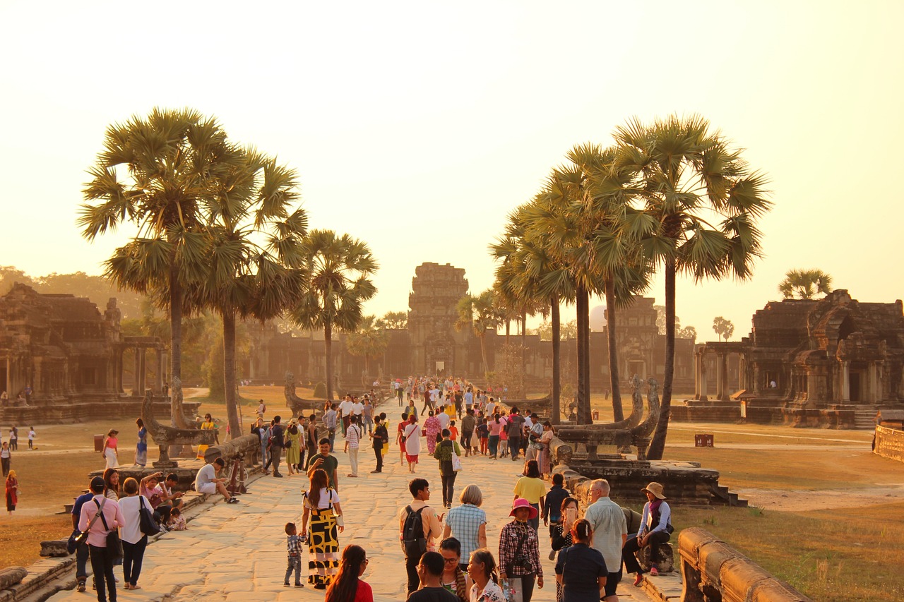 The iconic five towers of Angkor Wat reflected in a tranquil pond at sunrise.
